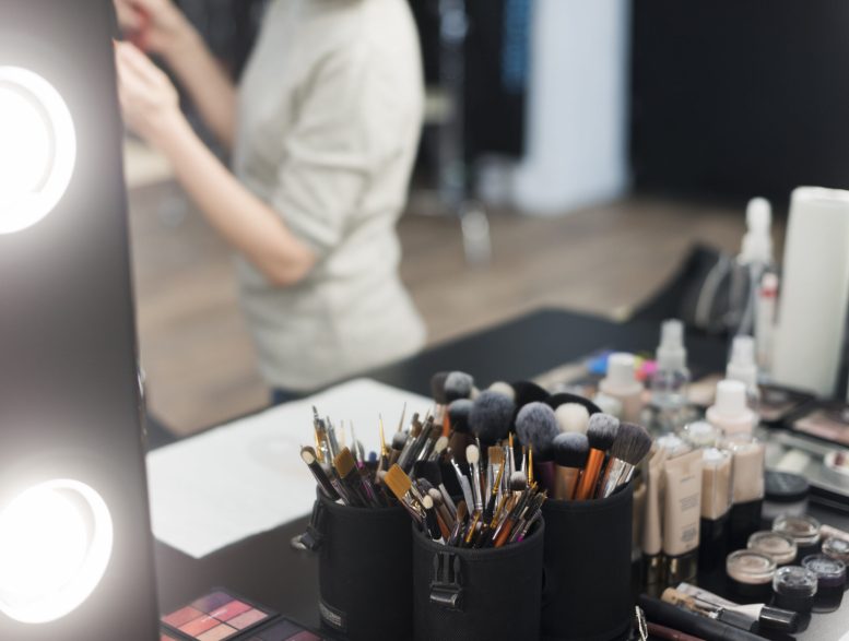 pinceles-de-maquillaje-y-cosmeticos-cerca-del-espejo